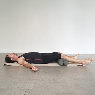 Man Reclining with EZ Clean Junior Yoga Bolster - Charcoal Under Knees