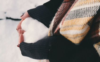 Woman Holding Heart Made of Snow