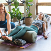 Woman Reclining on Round Bolster - Olive, Pranayama Bolster - Night Flight, Mexican Blanket - Olive